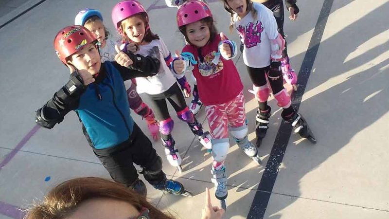 Monitora haciéndose un selfie con el grupo de patinaje infantil